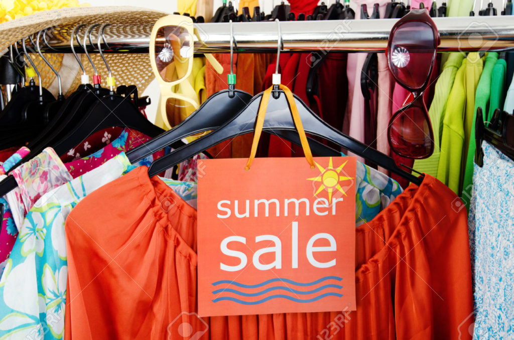 29455470-close-up-on-a-big-sale-sign-for-summer-clothes-clearance-rack-with-colorful-summer-outfits-and-acces-stock-photo